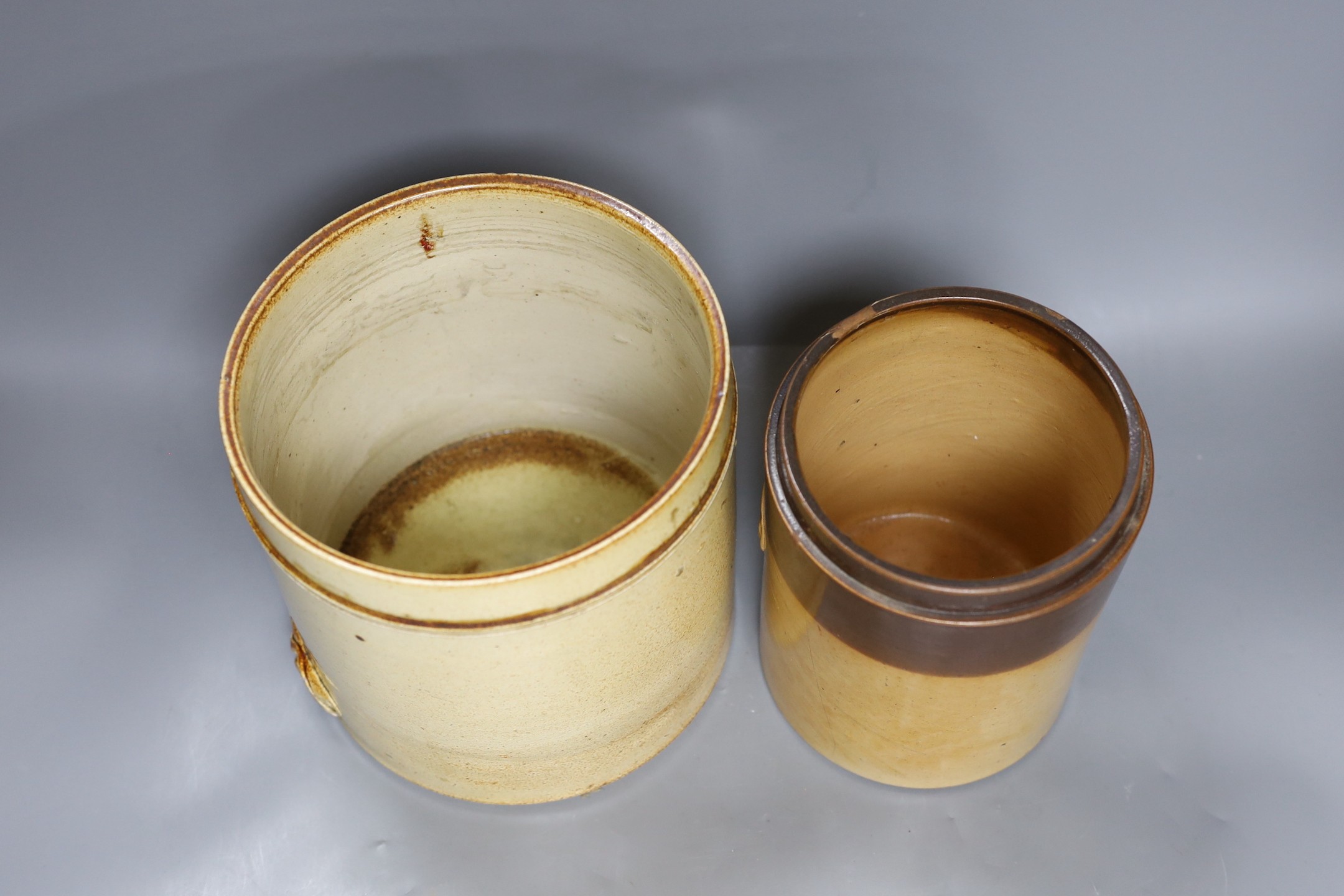 Two 19th century salt glazed stoneware cylindrical storage jars, both with Royal Coat of Arms sprigging, Tallest 20.5cm